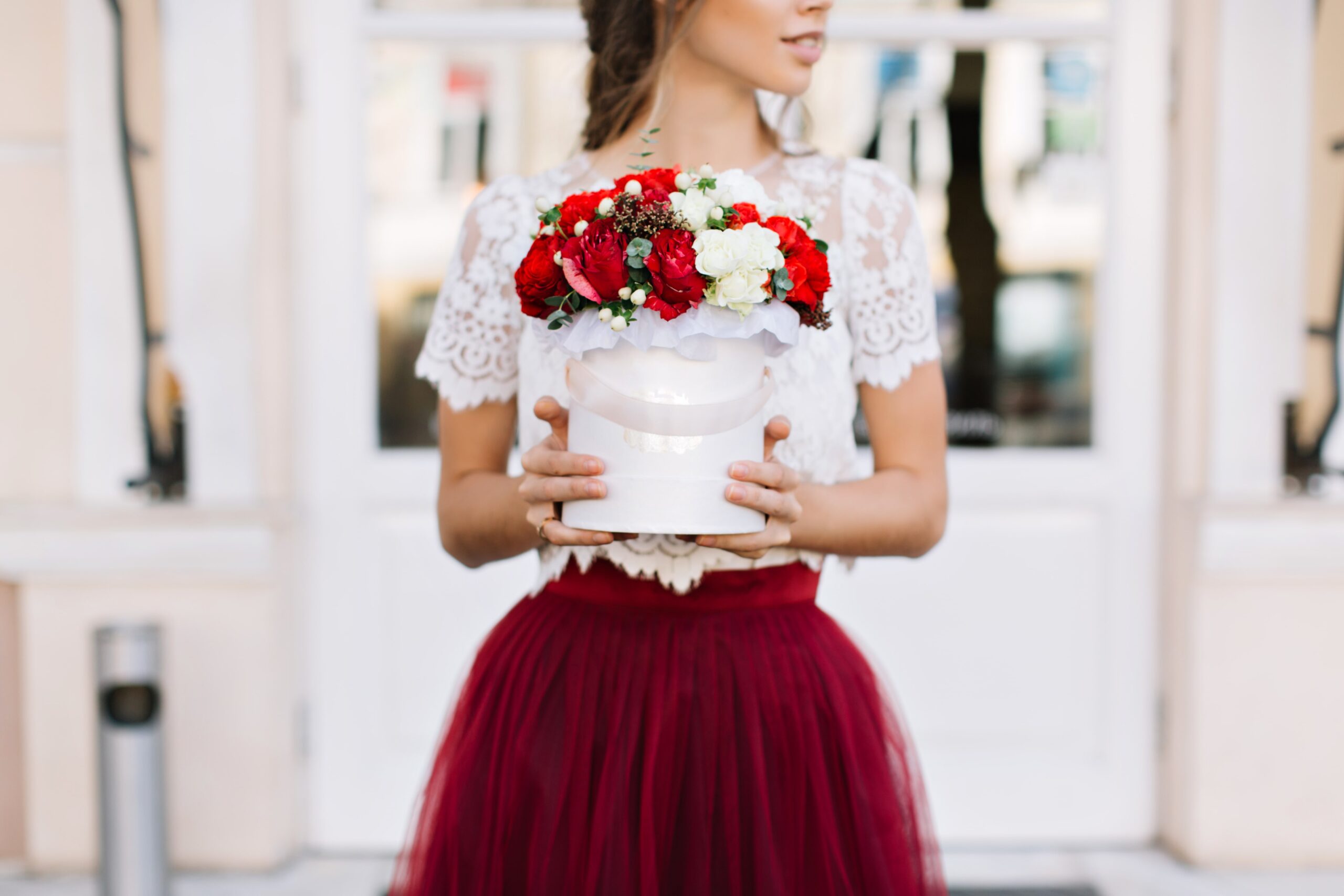 bouquet-red-white-flowers-hands-pretty-girl-tulle-marsala-skirt-street-min