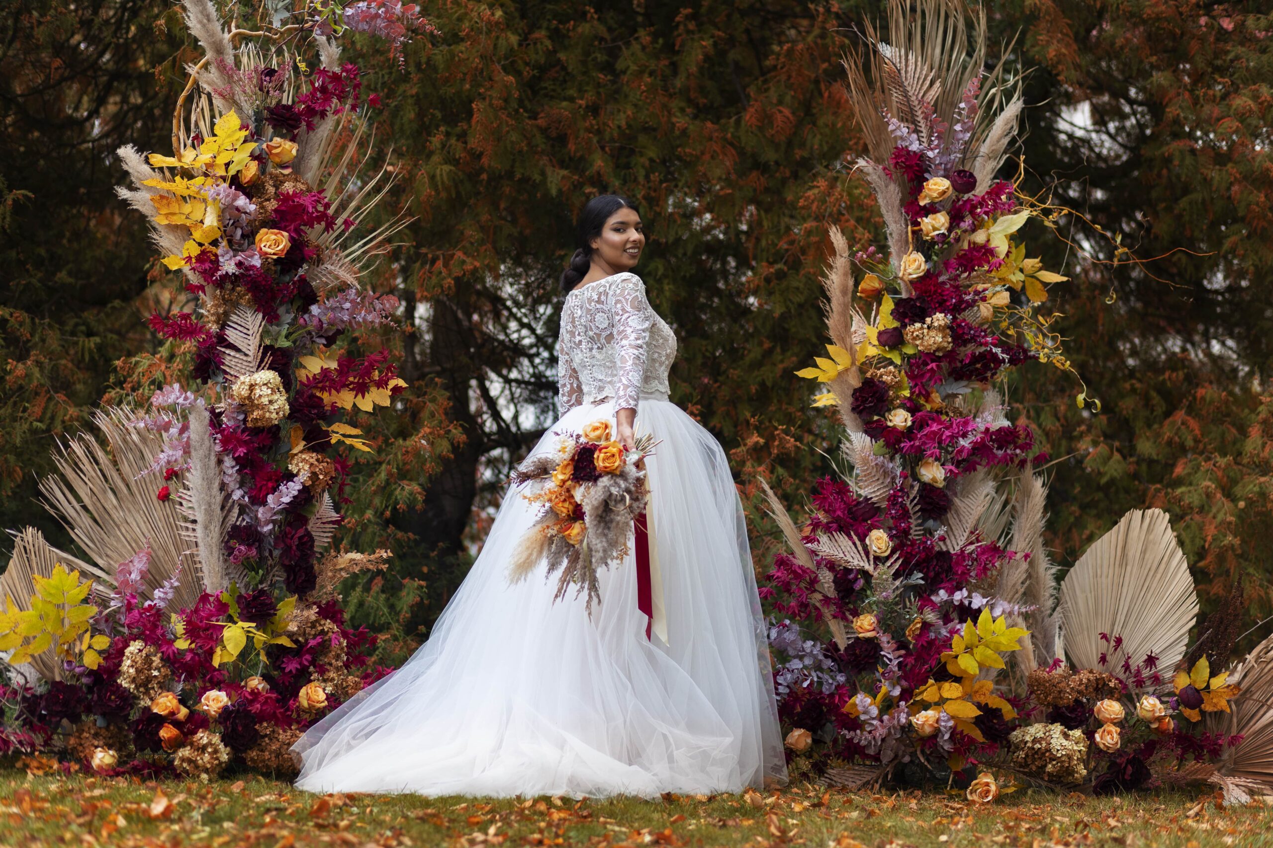 smiley-bride-posing-with-flowers-side-view-min